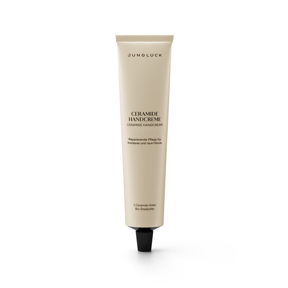 Beige tube of Junglück Ceramide Handcreme with black cap and black text detailing ceramide skincare benefits.