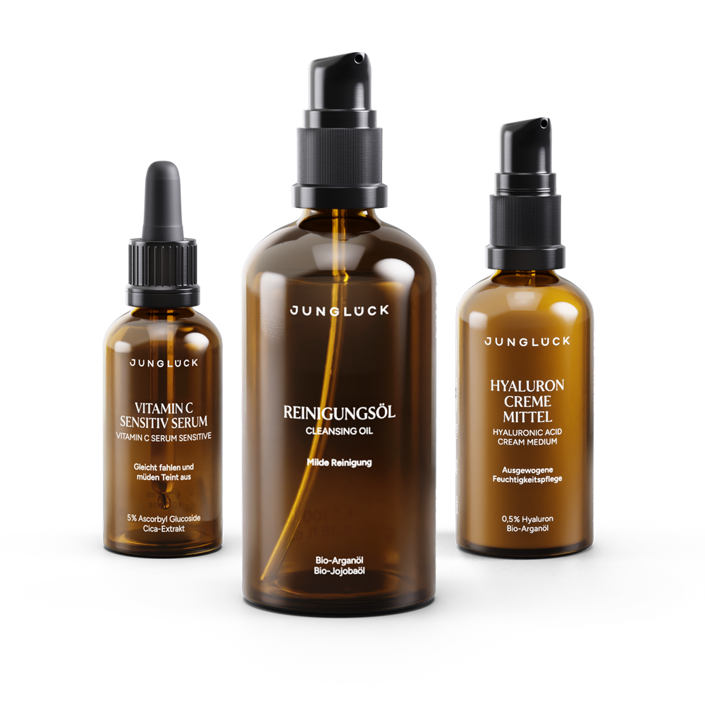 Amber glass skincare set with vitamin C serum, cleansing oil, and hyaluronic cream bottles.