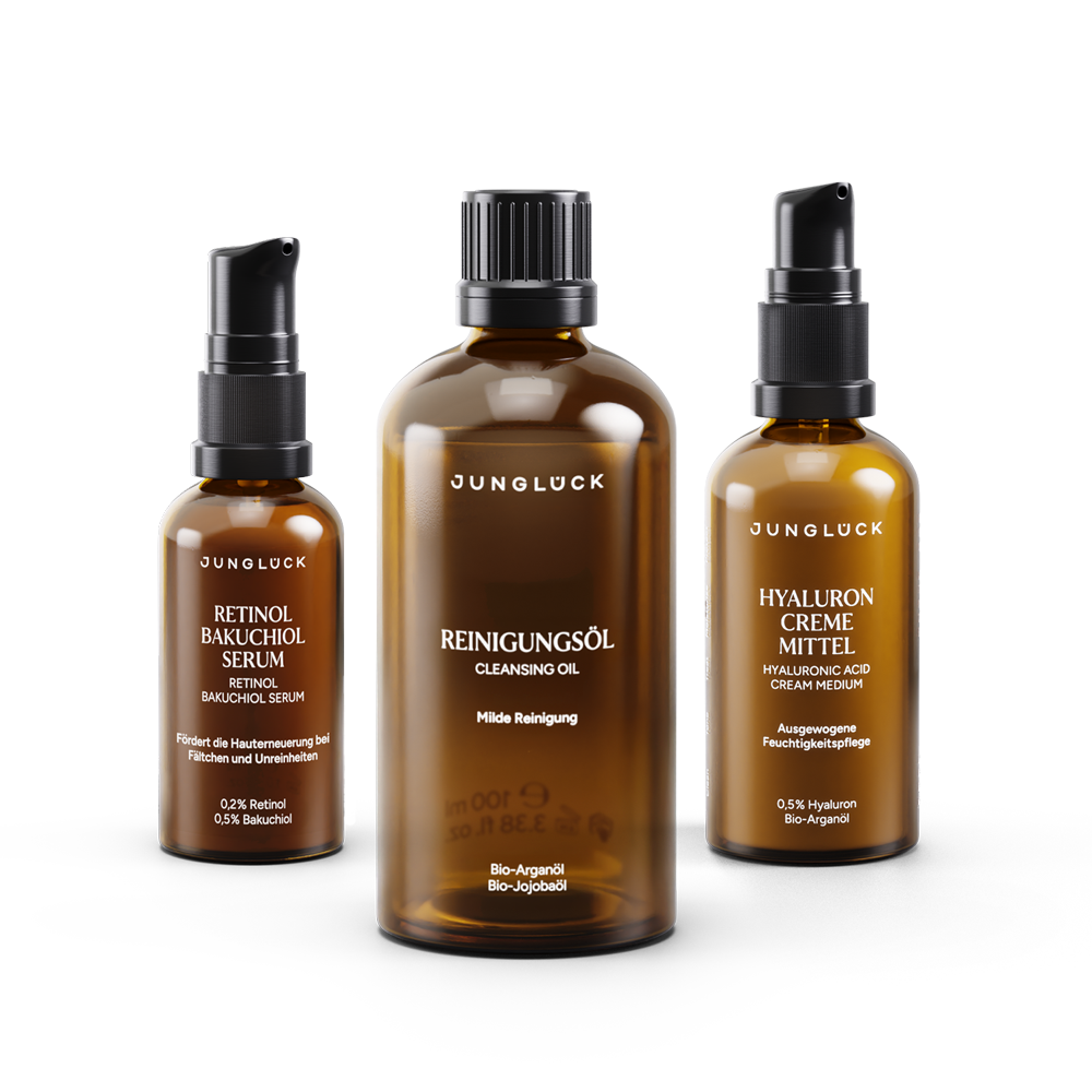 Set of three amber glass skincare bottles with black pump and screw caps, labeled Retinol Bakuchiol Serum, Reinigungsöl.