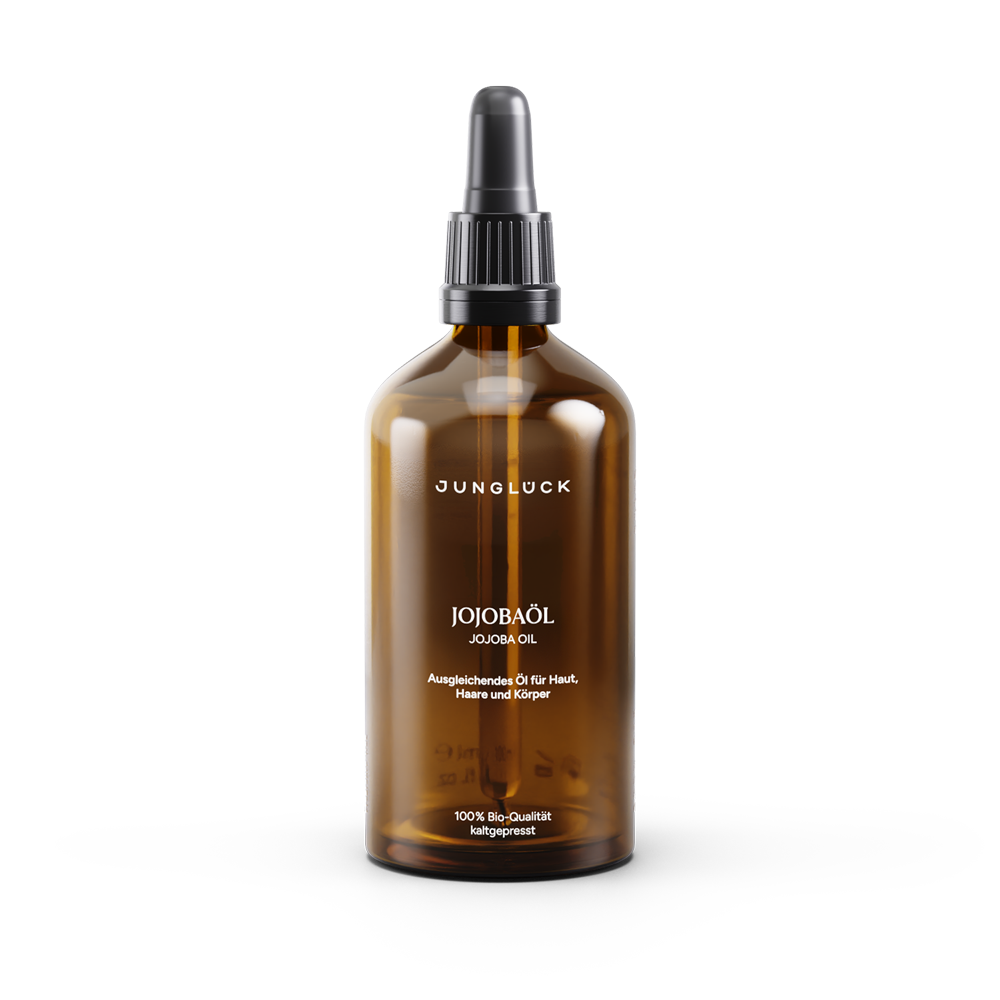 Amber glass bottle of alcohol-free jojoba oil with black pump dispenser and minimalist white label text.
