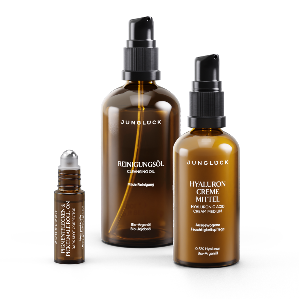 Three amber glass skincare bottles with black pumps and roller applicator for pigment spot and acne scar brightening set.