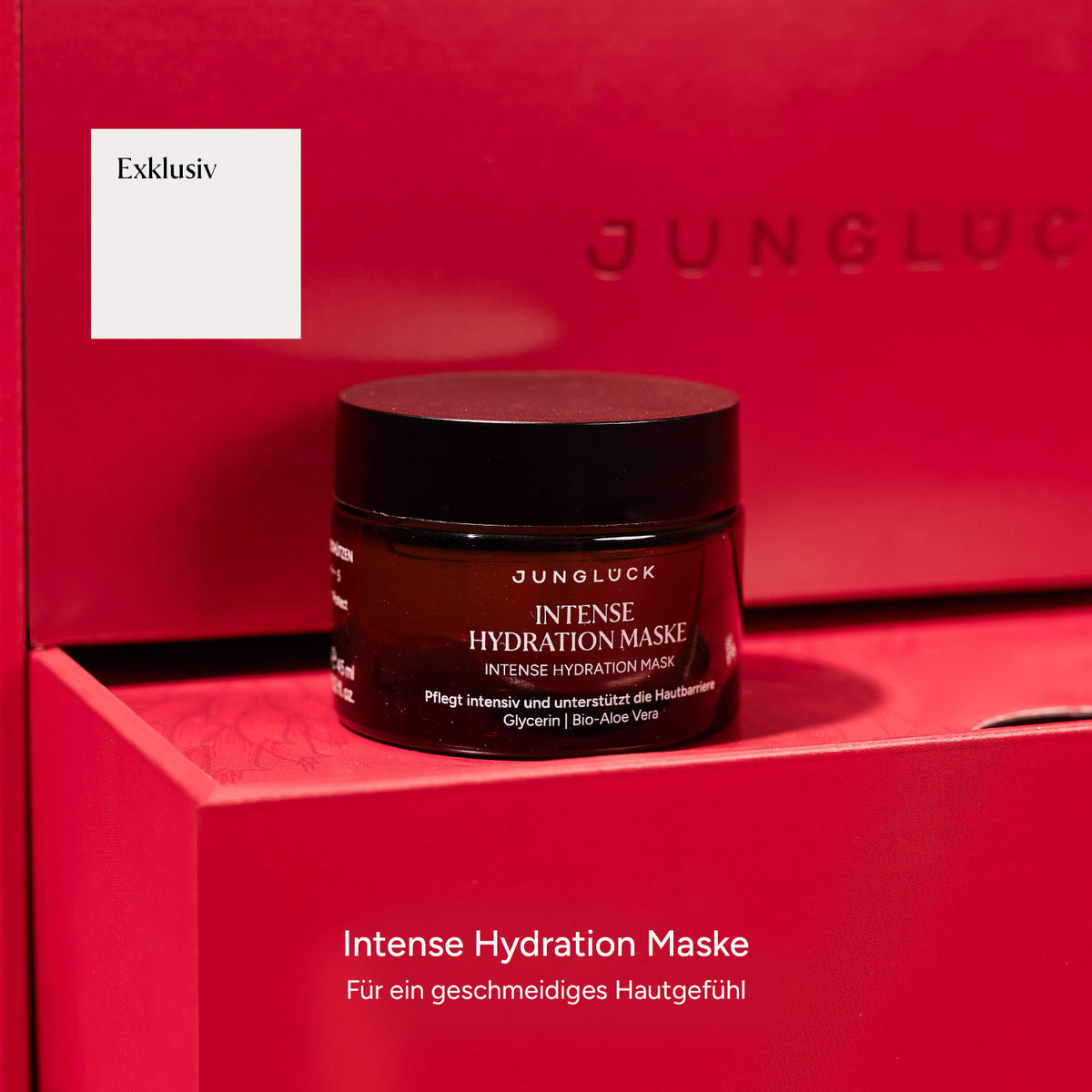 Braunglas jar der Intense Hydration Maske auf rotem Hintergrund, mit Textbeschreibung der Pflegewirkung.