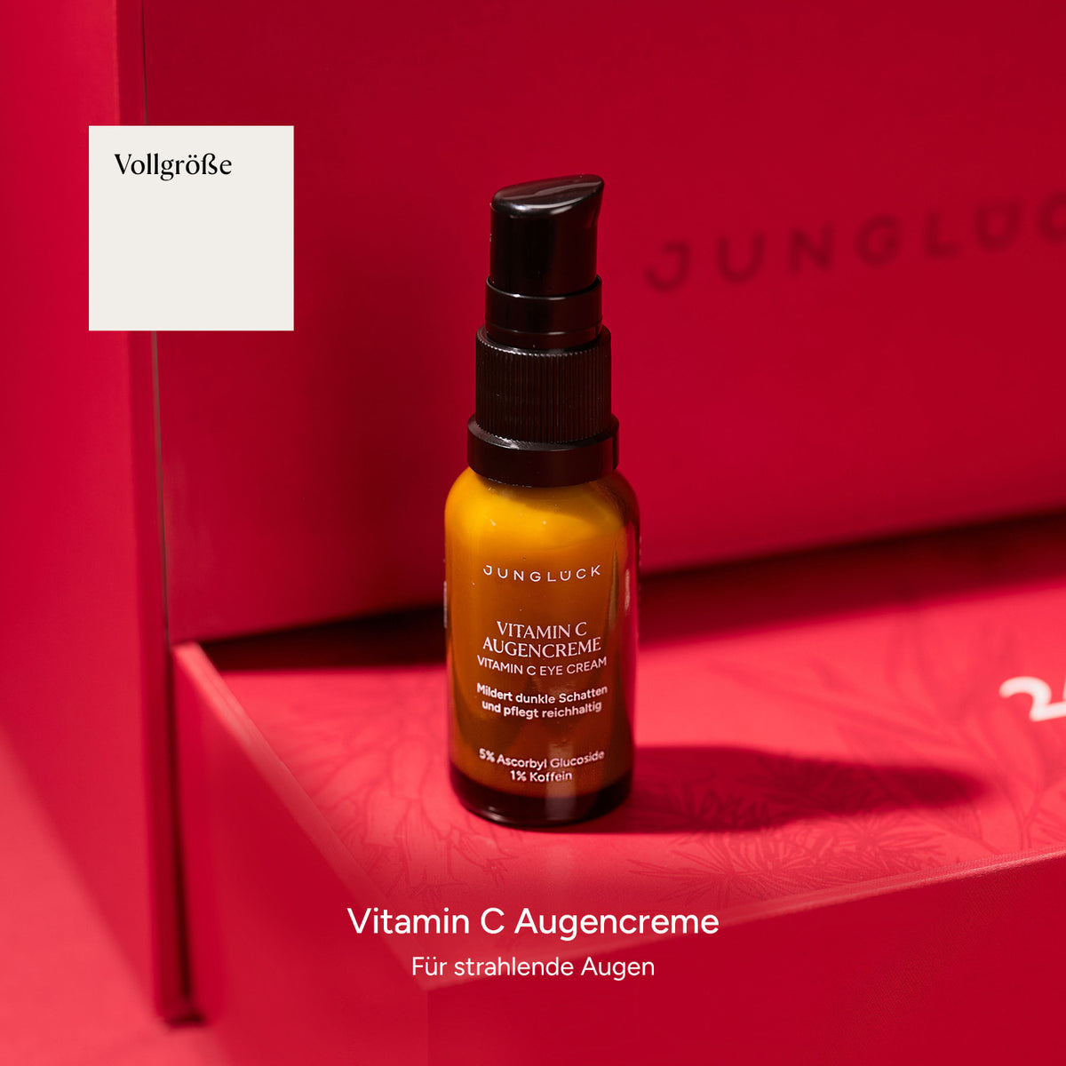 Braunglasflasche mit Vitamin C Augencreme vor pinkem Hintergrund, beschreibt die Verbesserung des Hautbilds.