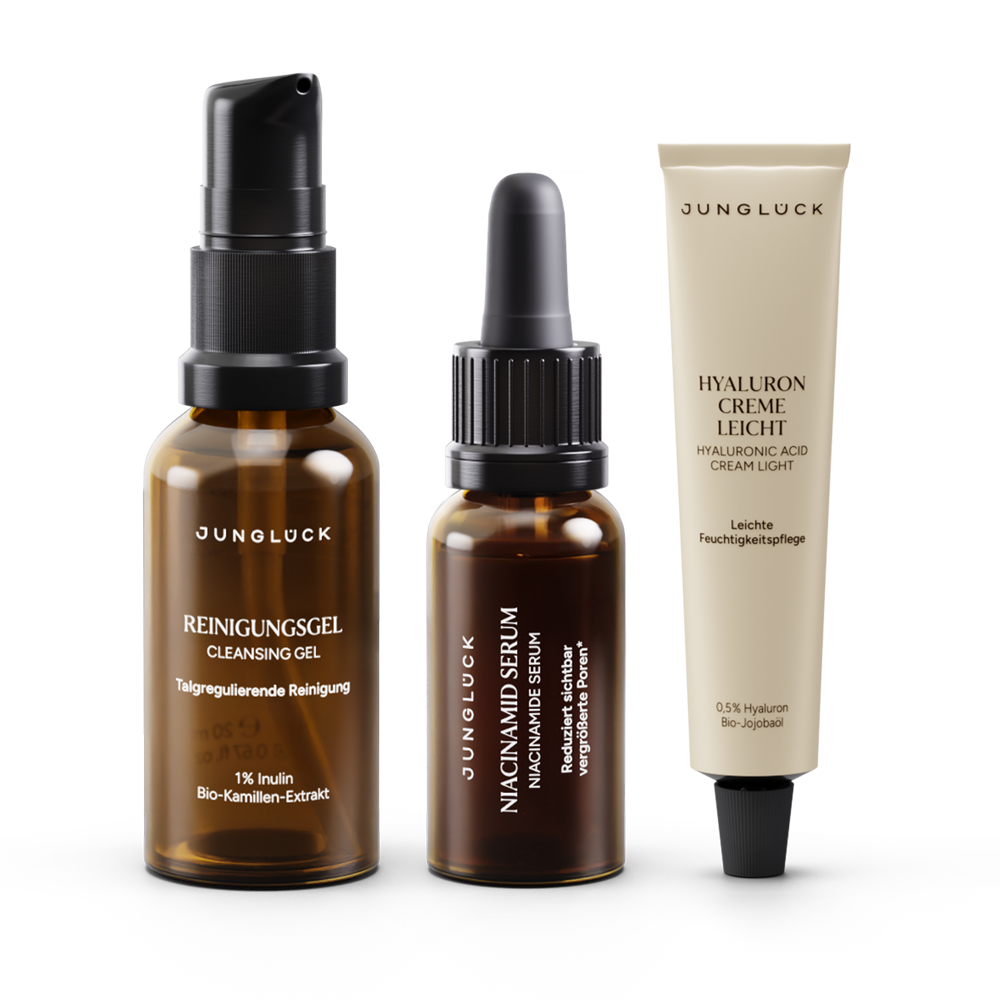 Drei JUNGLÜCK Produkte: ein Cleansing Gel, ein Niacinamid Serum und eine Hyaluron Creme leicht in typischen
