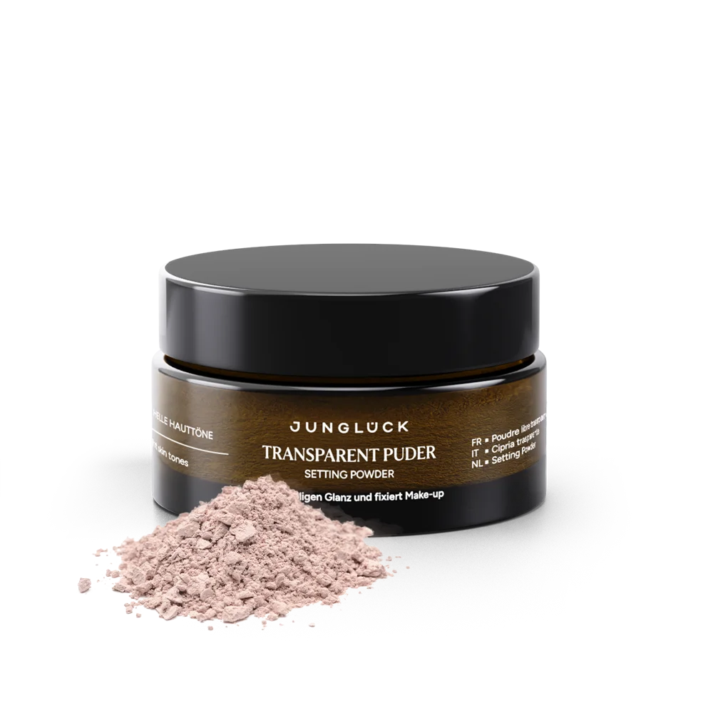 Transparent Puder in einer Braunglasflasche mit schwarzem Deckel, rosafarbene Pudertextur auf dem Tisch.