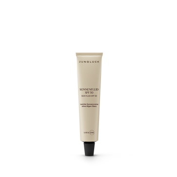 Beige 10ml tube of Junglück Sonnenfluid SPF 50 with black cap and minimalist black text.