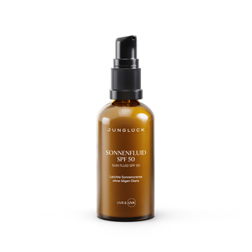 Amber glass bottle of Jungluck Sonnenfluid SPF 50 sunscreen with black pump dispenser and white text.