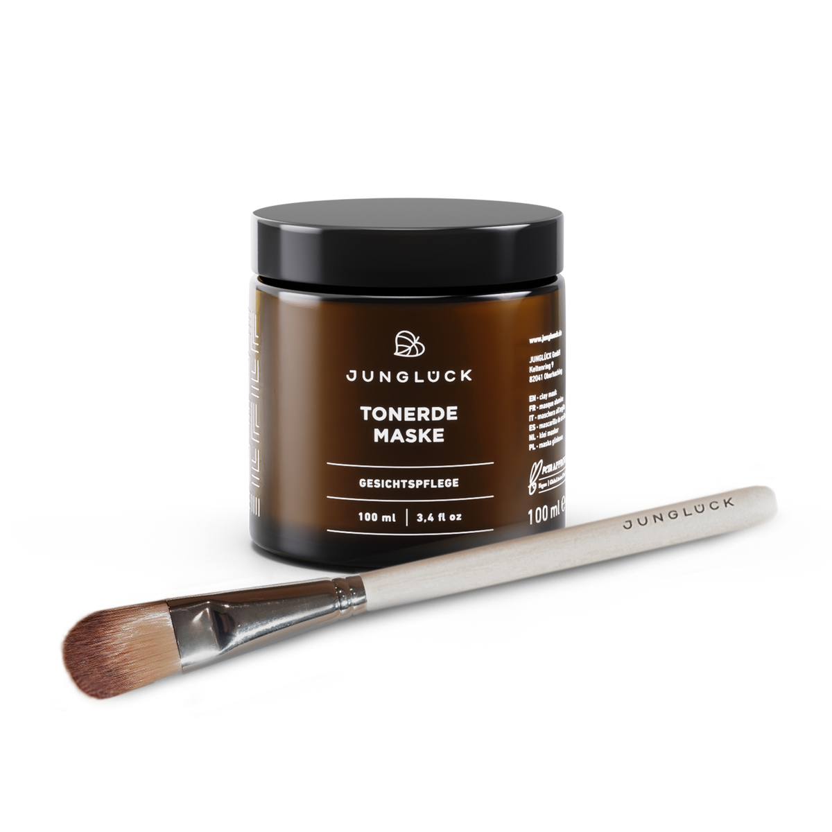 Tonerde Maske in einem 100 ml Braunglasbehälter neben einem Pinsel für die Anwendung.
