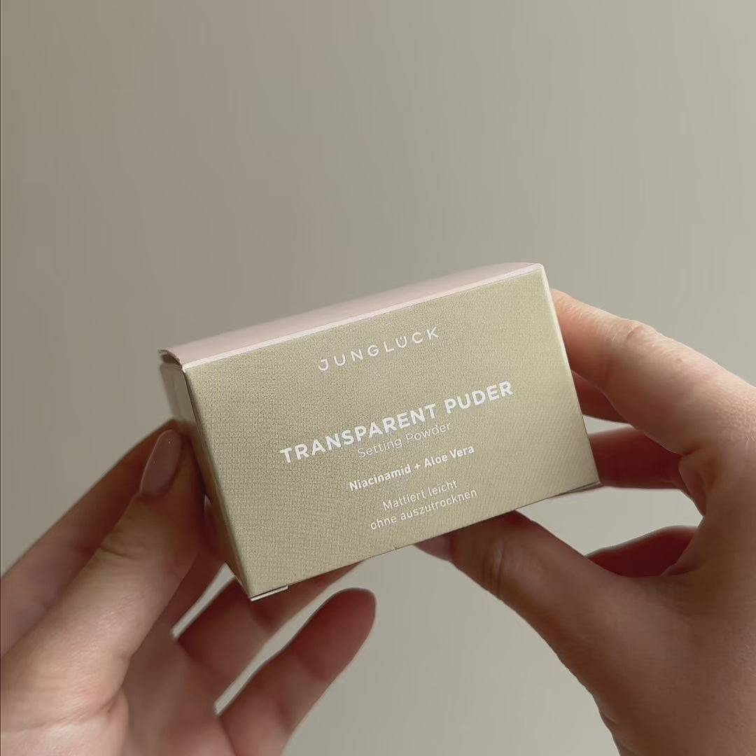 Junglück Transparent Puder wird von Frau mit Pinsel aufgetragen