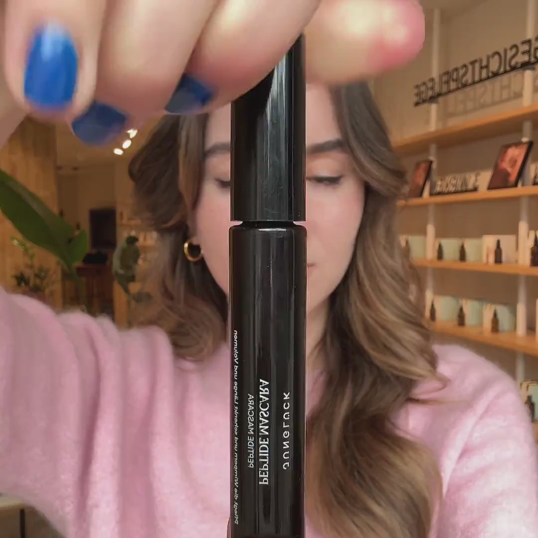 Junglück Mascara wird präsentiert und aufgetragen von junger Frau