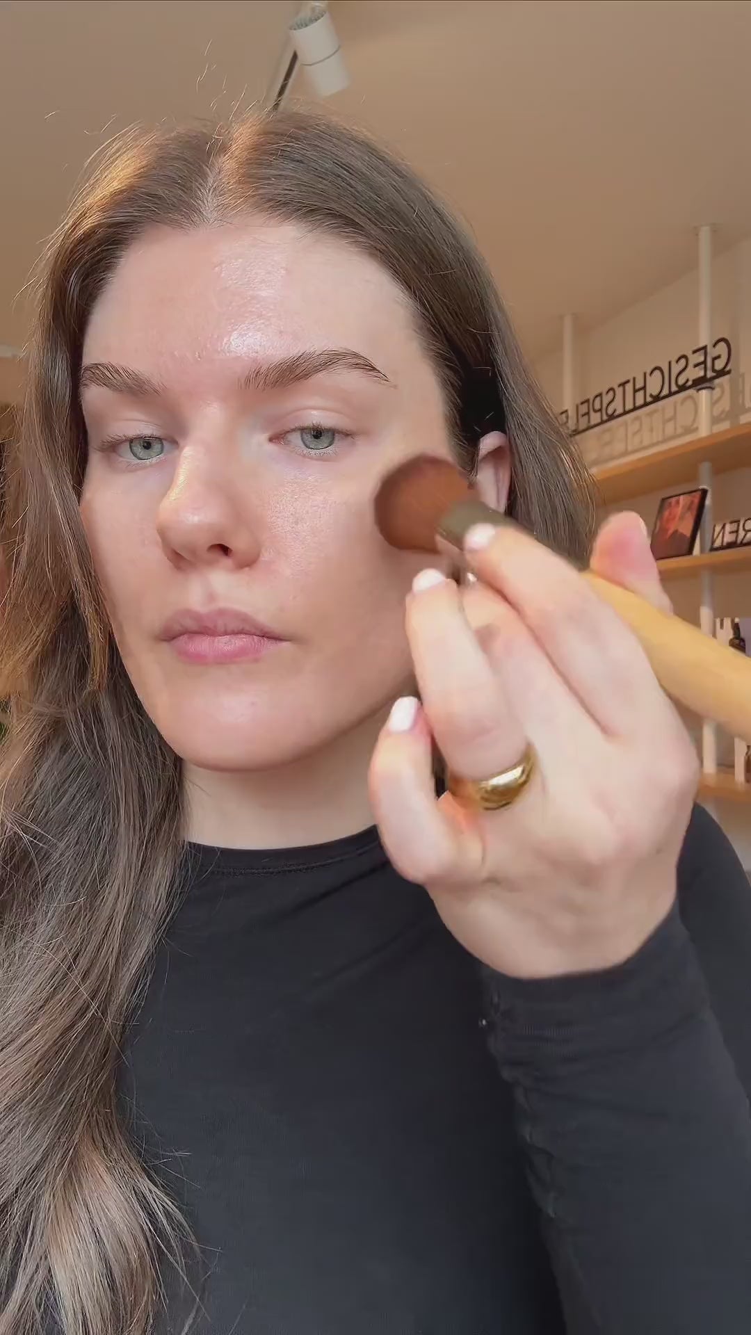 Junglück Getöntes Serum wird von Frau als Foundation, Concealer und Contouring aufgetragen mit Pinsel